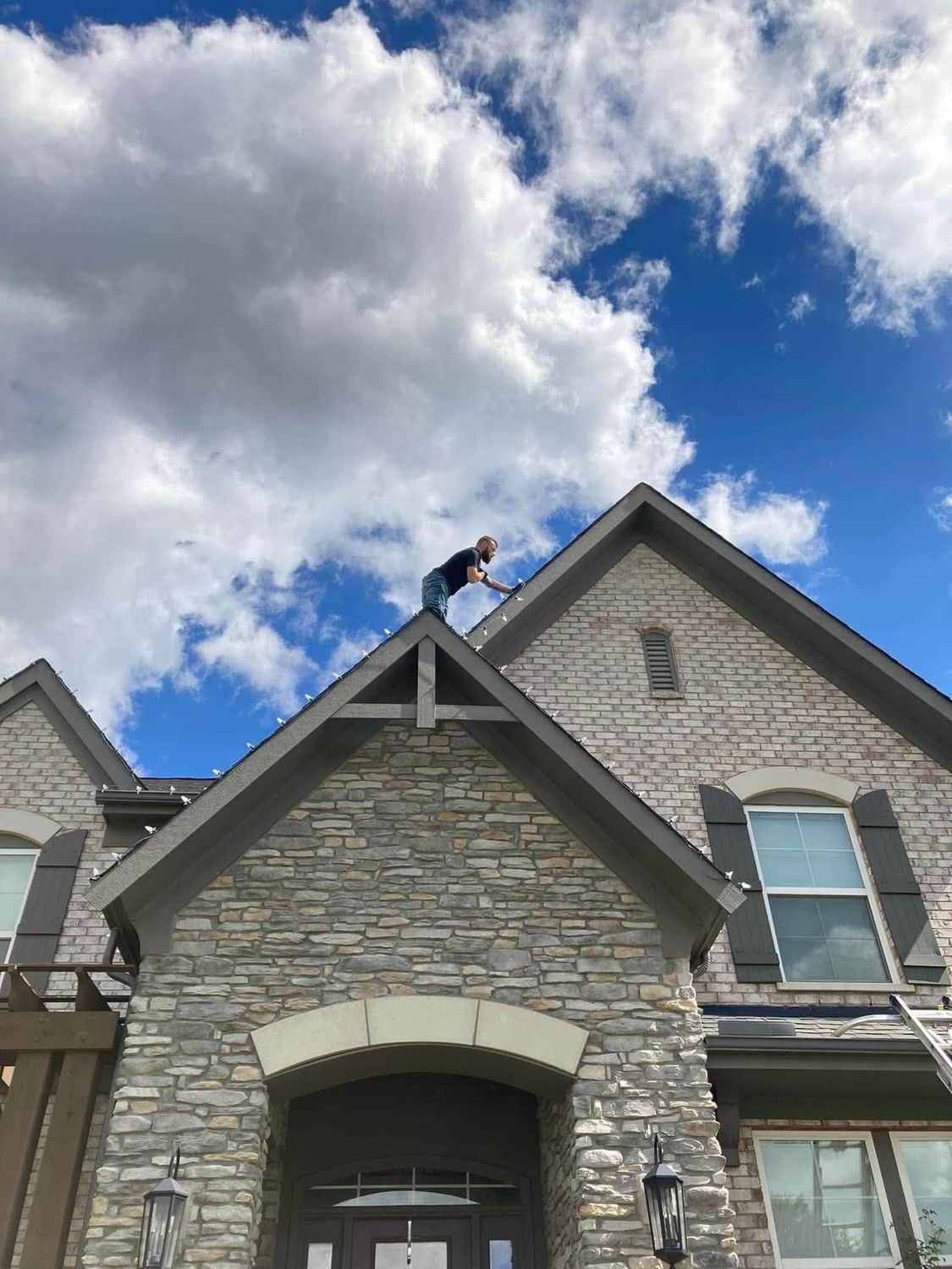 Up at the peak, setting the top line — Christmas light installation by Mike’s Cincinnati Christmas Lights