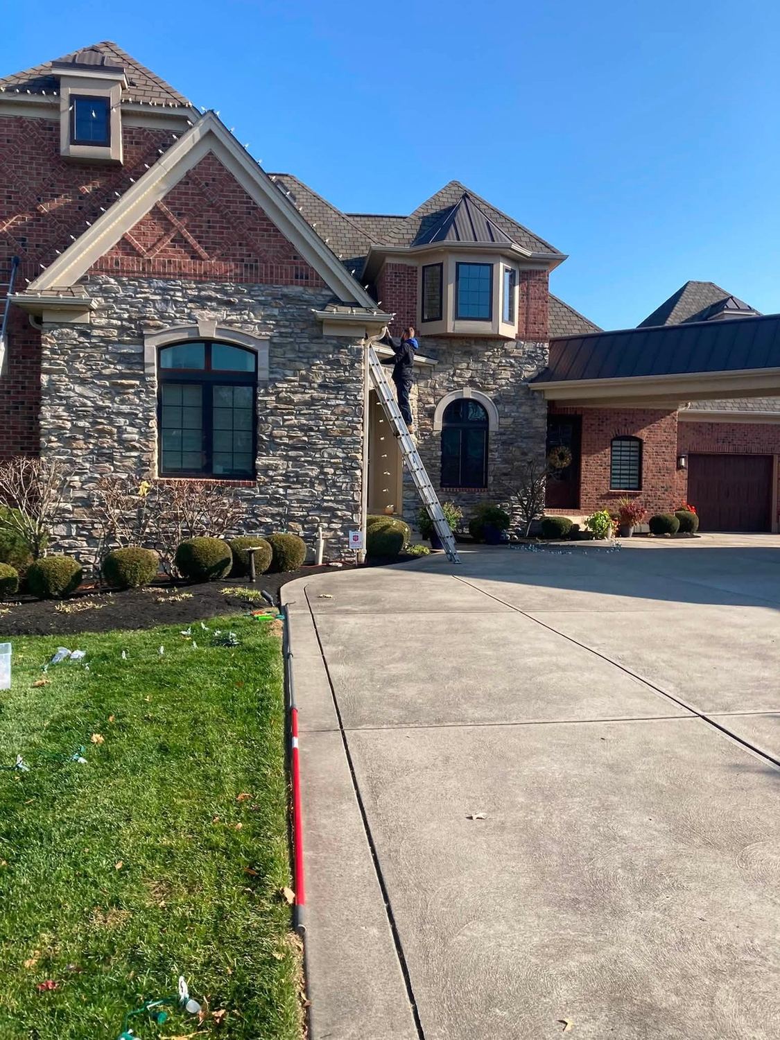 Stone frontage, ladder staged for the run &mdash; Christmas light installation by Mike&rsquo;s Cincinnati Christmas Lights
